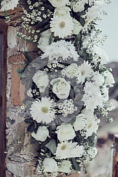 White wedding flowers adorn a wall