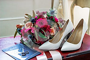 White wedding shoes bride, wedding rings and bouquet