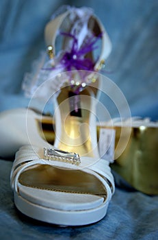 White wedding shoes and garter at the blue background