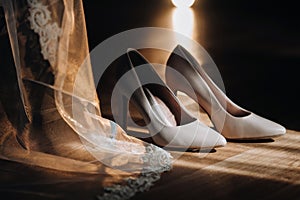 white wedding shoes standing on the field near the dress