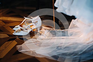 white wedding shoes standing on the field near the dress