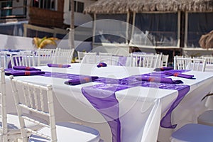 White wedding table decorated with purple bows on