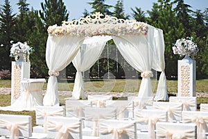 White wedding tent for the ceremony outdoors. Arch. Chairs.