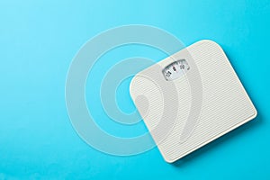 White weigh scales on blue background photo