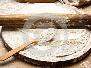White wheat flour in a wooden spoon, top view