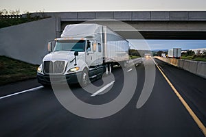 White 18 wheeler semi truck and overpass photo