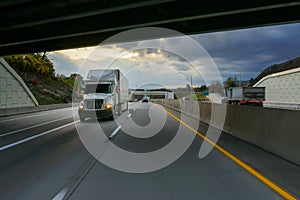 White 18 wheeler semi truck and overpass photo