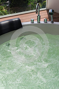 White whirlpool bathtub and bubbles with steel faucet and showerhead