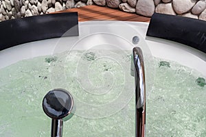 White whirlpool bathtub with water bubbles and steel faucet