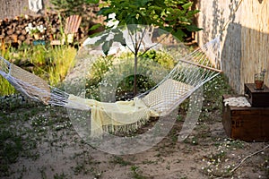 White wicker hammock with a pillow and blanket