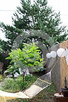 White wicker hammock with a pillow in the garden