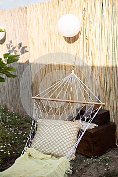 White wicker hammock with a pillow in the garden