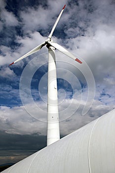 White wind mill turbine against the sky