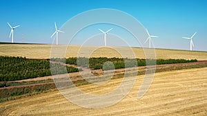 White wind power generators rotate in an agricultural field in Israel