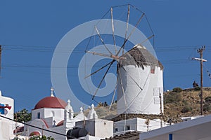 White windmill and church in town of Mykonos, Greece