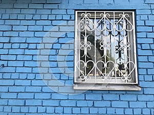 white window against the background of a blue brick wall