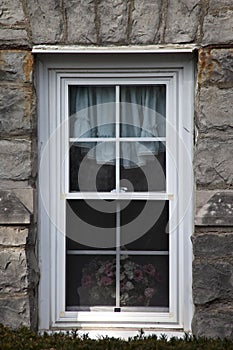 White window on aged rock wall