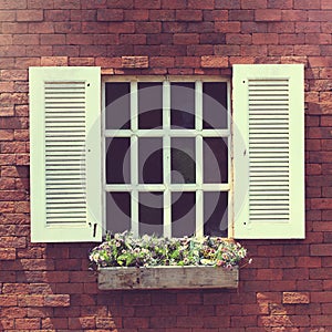 White window on a brick wall with a flower box