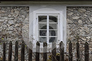 A white window on the old wall of a village house