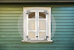 White window shutters and old green wood wall