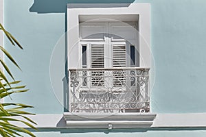 Window with small French balcony in neoclassical building in historic center of Cienfuegos, Cuba.