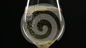 White wine being poured very quickly into a large wine glass