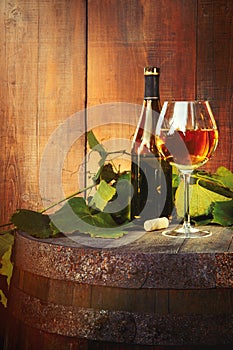 White wine bottle and glass on barrel