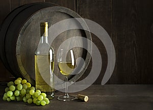 White wine bottle and glass with barrel background