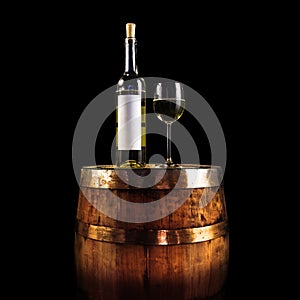 White wine bottle and glass on a wooden barrel - isolated on black