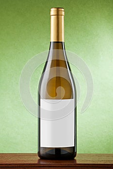 White wine bottle on green background.