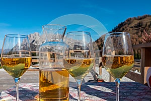 Sauris - White wine carafe and glasses with scenic view of majestic ridges of Carnic Alps photo
