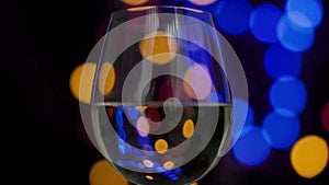 White wine in glass with blurred lights