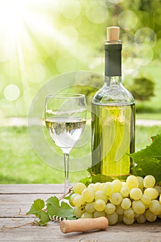 White wine glass and bottle with bunch of grapes