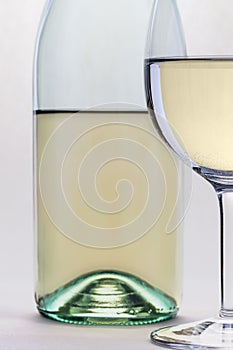 White wine glass and bottle closeup islolated on white background