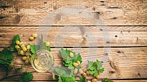 White wine glass and fresh grapes on wooden background, copy space