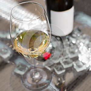 White wine in a glass with ice, old wooden background, selective focus