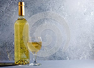 White wine in glass wine glasses, a bottle of wine. Blue background. Copy space