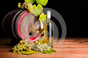 White wine and grapes in front of old barrel