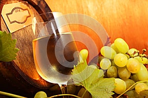 White wine with grapes and a wine barrel