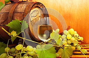 White wine with grapes and a wine barrel