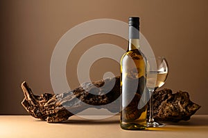 White wine and old snag on a beige background