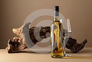 White wine and old snag on a beige background