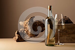 White wine and old snag on a beige background