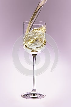 White wine poring into a crystal glass.