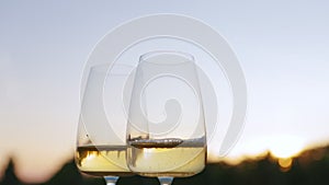 White wine poured into glasses at sunset outside