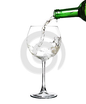 White wine pouring from the bottle intro the glass photo