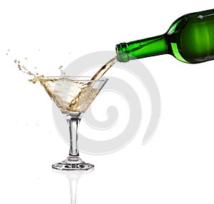 Wine pouring from the bottle intro the glass on white background photo