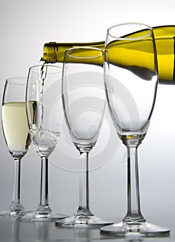 White wine pouring from bottle into wineglass