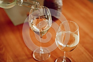 White wine pouring into the glass. view from above