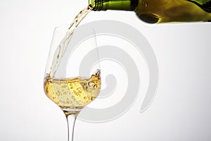 White wine pouring from green bottle, close up.